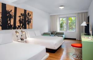 a hotel room with two beds and a couch at AxelBeach Miami South Beach - Adults Only in Miami Beach