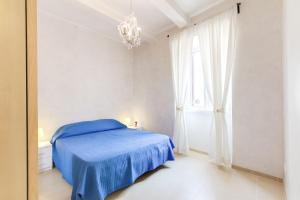 a bedroom with a blue bed and a window at Casa Monticelli in Rome