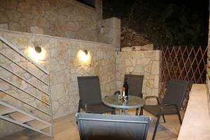 a patio with a table and chairs and a stone wall at Aknato in Vlikhón