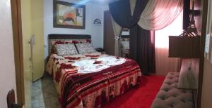um quarto com uma cama com um cobertor vermelho em Casa de Temporada Familiar em Urubici