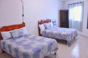 1 dormitorio con 2 camas, 1 cama y ventana en Hotel Posada Sernichari en Cuetzalán del Progreso