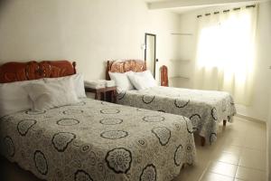 a hotel room with two beds and a window at Hotel Posada Sernichari in Cuetzalán del Progreso
