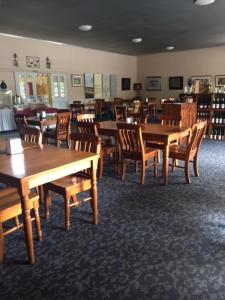 a dining room with wooden tables and chairs at Hill End Lodge in Hill End