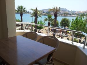 a table and chairs on a balcony with a view of the water at Aydeniz Apart Hotel in Datca