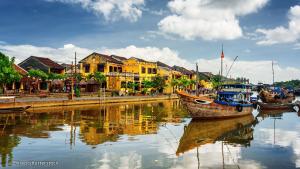 a group of boats sitting in a river with houses at RedRose Villa in Hoi An