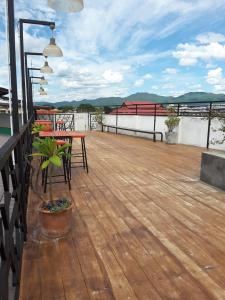 a wooden deck with tables and chairs on a roof at Huglampang Boutique Hotel in Lampang