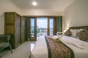 - une chambre avec un grand lit et une fenêtre dans l'établissement Pondok Tamiu, à Ubud