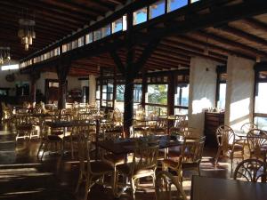 a dining room with tables and chairs and windows at HOTEL ALTAVISTA in Zacatlán