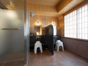 a bathroom with a sink and a toilet with two stools at PACIFICO Hotel and Spa in Iwaki