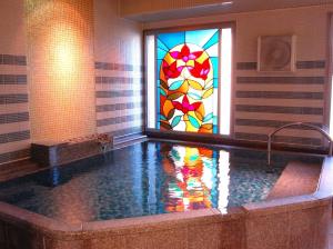 a bathroom with a tub with a stained glass window at PACIFICO Hotel and Spa in Iwaki