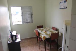 um quarto com uma mesa com cadeiras e uma janela em Casa mobiliada em São Paulo