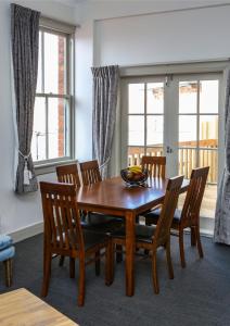a dining room with a wooden table and chairs at The Prospect of Howick Accommodation in Auckland