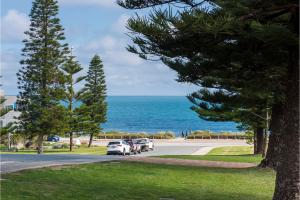 
a beach scene with a car parked on the side of the road at Cottesloe Sunset on Salvado in Perth
