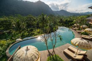 einen Pool mit Stühlen und Sonnenschirmen neben einem Berg in der Unterkunft Wapa di Ume Sidemen in Sidemen + 37 Fotos
