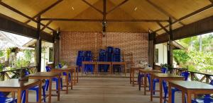 a room with wooden tables and blue chairs at Sunari Beach Resort 2 in Padang