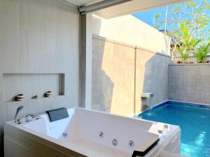 e bagno con vasca e piscina. di Theanna Villa and Spa Canggu a Canggu