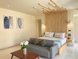 a bedroom with a bed and a couch at Theanna Villa and Spa Canggu in Canggu