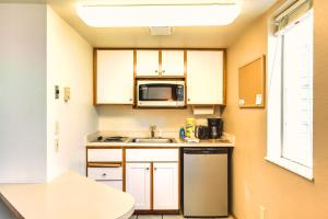 a small kitchen with a sink and a microwave at Turning Leaf Townhome Suites in Spokane