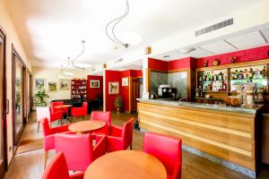 ein Restaurant mit roten Stühlen und einer Bar in der Unterkunft Hotel Miage in Aosta