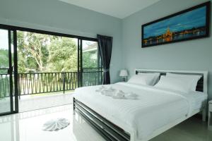 a bedroom with a large white bed and a balcony at Saree Lagoon Villa Koh Samui in Lipa Noi