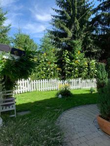 Ein weißer Lattenzaun in einem Garten mit einer Bank in der Unterkunft Allgäuvilla in Scheidegg