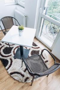 una mesa, una silla, una mesa y una alfombra en Нові Апартаменти, en Lyubomirka