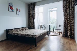 Un dormitorio con una cama y una mesa y una ventana. en Нові Апартаменти, en Lyubomirka