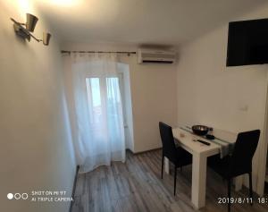a small room with a table and chairs and a window at Apartman in Cres