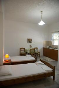 a room with two beds and a table with a lamp at Soldatos Rooms in Marantochori