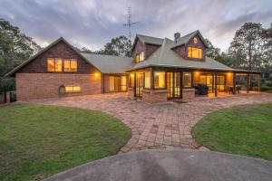 a large brick house with windows and a driveway at A Hidden Bush Delight in Dunsborough