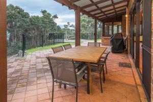 a wooden table and chairs on a patio at A Hidden Bush Delight in Dunsborough