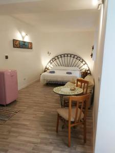 a bedroom with a bed and a table and chairs at casa Tuccari Castiglione di Sicilia in Castiglione di Sicilia
