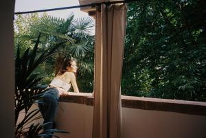 Eine Frau, die auf einem Felsvorsprung sitzt und aus dem Fenster schaut. in der Unterkunft Villa Arnica in Lana