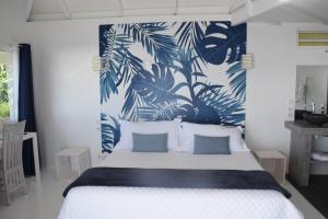 a white bed with a white comforter and pillows at Ninamu Pearl Guest House in Punaauia
