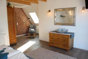 a bedroom with a dresser and a mirror on the wall at Eulenhaus Osterhever in Osterhever