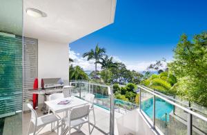 een appartement met een balkon met een tafel en stoelen bij Allambi Apartment 1, 25 Allambi Rise, Little Cove in Noosa Heads