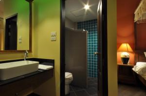 een badkamer met een wastafel, een toilet en een douche bij Wualai Sabaidee in Chiang Mai