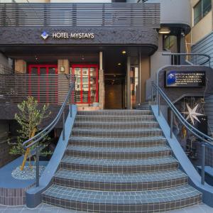 um conjunto de escadas que levam a um hotel com uma porta vermelha em HOTEL MYSTAYS Shinsaibashi em Osaka