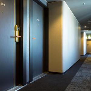 korytarz z niebieskimi ścianami i drzwiami w budynku w obiekcie HOTEL MYSTAYS Shinsaibashi w Osace