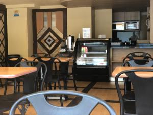 an empty restaurant with tables and chairs and a refrigerator at Ibeurohotel Guadalajara Expo in Guadalajara