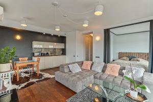 a living room with a couch and a table at Vilnius city best view apartments in Vilnius
