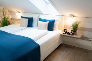 ein Schlafzimmer mit einem großen weißen Bett mit blauen Kissen in der Unterkunft Gästehaus an der Sempt - Wohlfühlen auf dem Lande in Erding