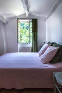 - une chambre avec un grand lit et une fenêtre dans l'établissement B&B le boissol, à Entrechaux