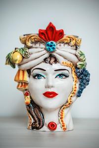 un busto de cerámica de una mujer con sombrero de fruta en Mediterraneo Palace Luxury Affittacamere, en Pachino