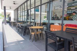 a row of tables and chairs in a restaurant at Hotel 99 Sepang KLIA & KLIA2 in Sepang