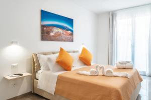 1 dormitorio con 1 cama con 2 chanclas en Mediterraneo Palace Luxury Affittacamere, en Pachino