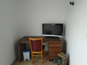 Elle comprend un bureau avec un ordinateur, une télévision et une chaise. dans l'établissement maison en bord de mer wifi, à Fos-sur-Mer
