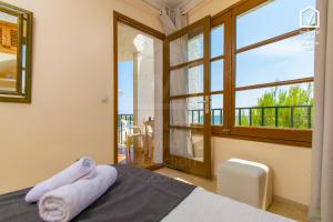 a bedroom with a bed and a large window at Apartamentos Carabela CITADINI 39 in Alcudia