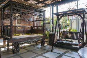 a wooden bench sitting on top of a porch at RedDoorz Syariah near RRI Malang in Malang