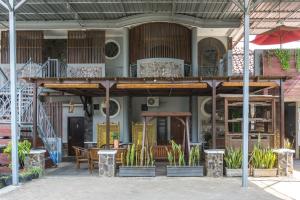 a building with a balcony with tables and chairs at RedDoorz Syariah near RRI Malang in Malang